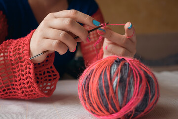 female hands crocheting colorful yarn. multicolor yarn wool textured pattern for crochet
