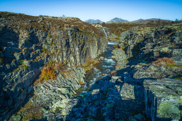 Rocky canyon landscape with distant Norwegian mountains