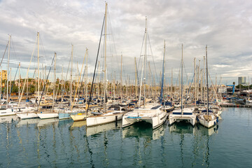 Fototapeta premium Great panoramic view of the port of Barcelona with a Ferris wheel and many sailing boats docked in the port, Spain.