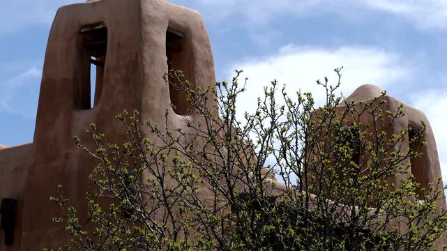 Trees and shrubs frame historic 19th and 20th century buildings in and around the Plaza in Santa Fe, New Mexico, USA