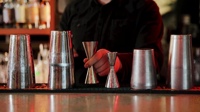 Bartender pouring liquor into jigger for cocktail