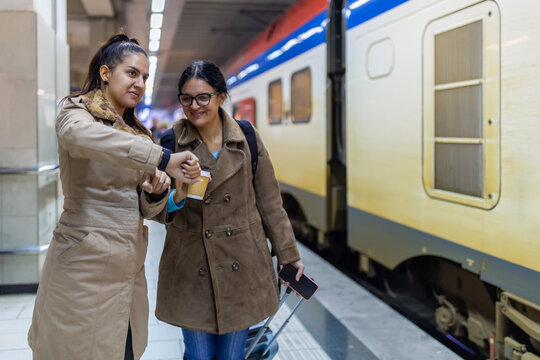 Women travelers checking smartwatch on train platform - Powered by Adobe