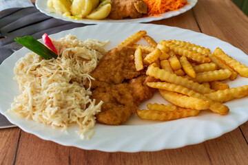 Crispy crinkle-cut fries, breaded cutlet, and creamy shredded cabbage salad arranged on a white plate. A classic comfort food set perfect for menu design, cooking blogs, and fast-casual dining themes.