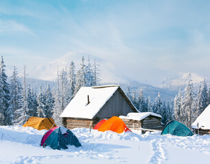 Winter calm mountain landscape with sheds and tourist tent group. Kukol Mount, Carpathian Mountains, Ukraine.