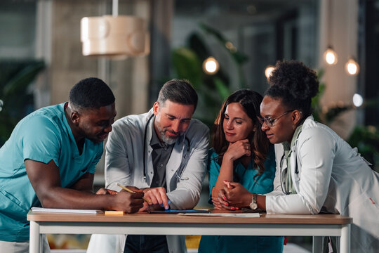 Diverse medical team collaborating on digital tablet - Powered by Adobe