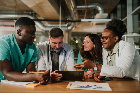 Diverse medical team collaborating on digital tablet - Powered by Adobe