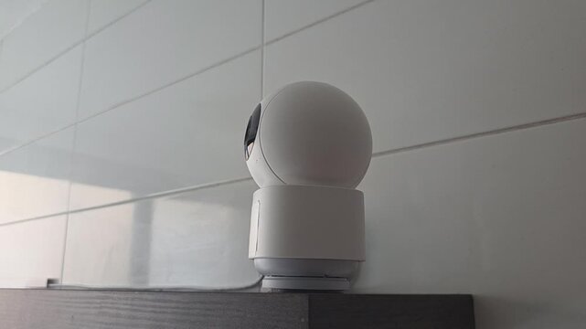 Rotating security camera on shelf capturing diverse angles. Indoor scurity camera - automatic tracking of a moving object