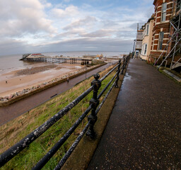The cliff top footpath overlooking the sandy beach and sea in the coastal town of Cromer, North Norfolk Coast. Ultra wide angle view