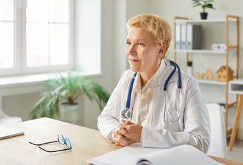Portrait of a senior woman doctor or nurse working in hospital office, focusing on everyday...