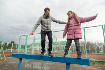 father and daughter playing on the sports ground on stadium at autumn