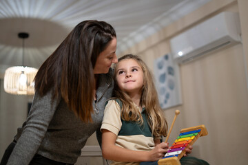 Mother and daughter bonding over music lesson at home