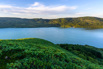 Scenic view of a tranquil lake surrounded by lush green hills in Russia