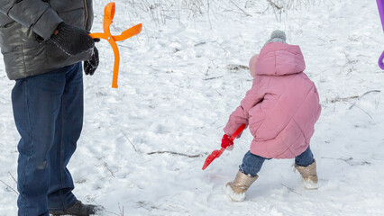 Little girls with her grandfather walk in a snowy forest, have fun together
