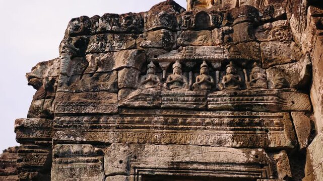 Ancient stone bas reliefs and sculptures depicting religious figures on the wall of the bayon temple in angkor, Cambodia, Siem Reap. Archeology concept.