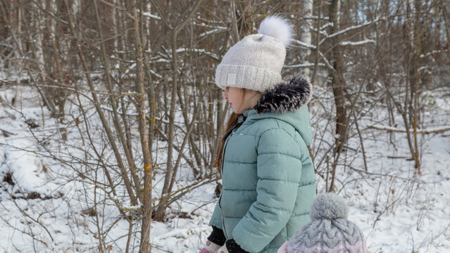 Little girls with her grandfather walk in a snowy forest, have fun together