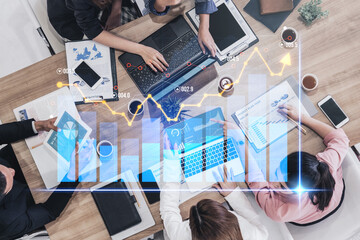 Diverse business professionals analyze financial data and strategies together. Digital graphs and charts enhance collaboration in a contemporary office environment. Scalp