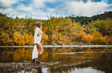 woman exploring rural algarve landscape by river in autumn light