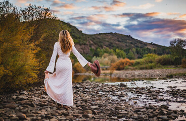 woman walking along a river at sunset in rural algarve countryside