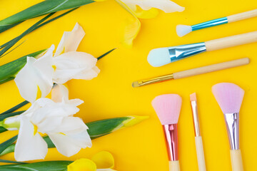 Vivid yellow backdrop with floral cosmetics theme, Elegant spring flatlay featuring daffodils makeup essentials and feminine skincare elements on lively yellow background