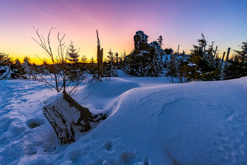 Snowy landscape at Třístoličník before sunrise, glowing horizon, winter forest silhouettes and soft pastel sky creating a cold, atmospheric scene ideal for seasonal designs and nature backgrounds.