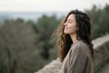 Peaceful woman with closed eyes enjoying nature