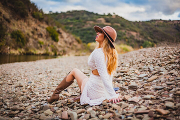 Woman relaxing by a riverside in the Algarve mountains during travel adventure