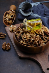 Peeled walnuts in wooden bowl isolated on wooden background. Top view.