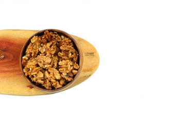 Peeled walnuts in wooden bowl isolated on white background. Top view.