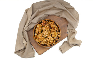 Peeled walnuts in wooden bowl isolated on white background. Top view.