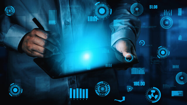 A person interacts with a tablet surrounded by a glowing digital interface, symbolizing modern technology and data analysis in a sleek workspace environment. Xenic