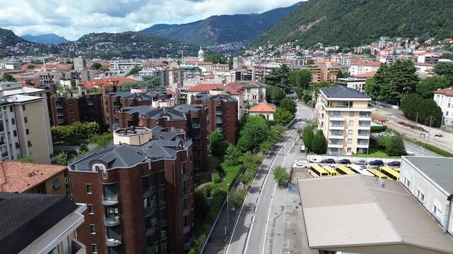 aerial drone view of historic palaces in Como city center with the blue waters of Lake Como in the background