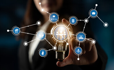 A businesswoman interacts with a lightbulb symbolizing innovation, surrounded by digital icons representing technology, networking, and growth in a modern setting. Crux
