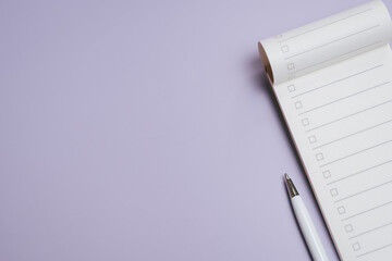 Check list concept. Checklist notepad with pen on purple background, empty task list for organization and planning, minimal workspace concept with copy space for text or design