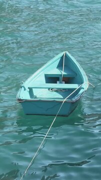 t&uuml;rkisfarbenes Boot schaukelt auf t&uuml;rkisfarbenem Wasser
