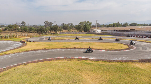 Motociclistas haciendo pruebas de manejo en pista de karting.