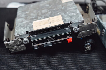 Old car stereo head units (radios or cassette decks) on a workbench in an auto service garage. Repair, diagnostics, and maintenance of vintage automotive audio equipment.