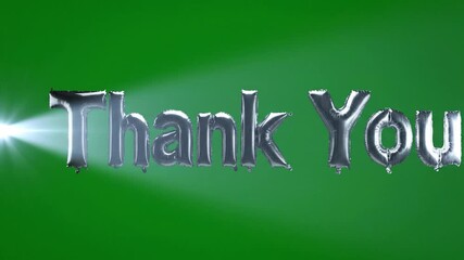 Silver foil balloon letters spelling Thank You floating and shimmering with a light beam on a vibrant green screen for gratitude concept and appreciation
