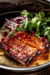Glazed pork ribs with herbs and onions