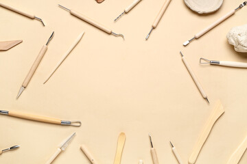 Frame made from set of sculptor tools on beige background