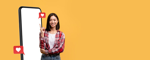 A young woman stands beside a large smartphone, smiling confidently while holding a snack. Social media icons float nearby, emphasizing her connection to digital platforms and engagement.