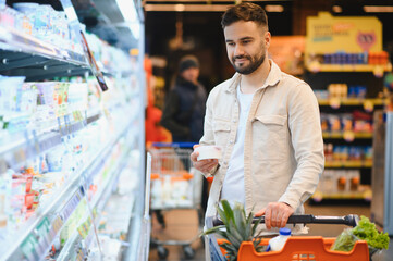 Man shopping for groceries in supermarket aisle