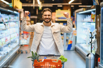 Happy man celebrating successful grocery shopping experience