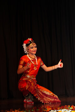 Smiling teenage girl performing traditional Indian Bharatnatyam dance