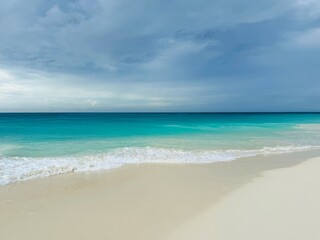 Waves breaking on a tropical sandy beach with turquoise water, Eagle Beach, Aruba