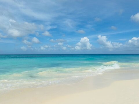 Waves breaking on a tropical sandy beach with turquoise water, Eagle Beach, Aruba
