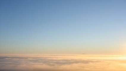 Fototapeta premium Aerial view above clouds at sunrise with blue sky and golden horizon, peaceful cloudscape from airplane window perspective