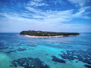 Fototapeta premium Tropical island surrounded by shallow turquoise reef