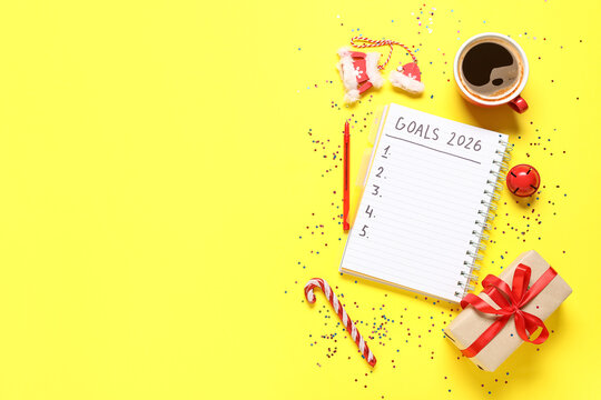 Notebook with 2026 to-do list, cup of coffee, gift box and Christmas decor on yellow background - Powered by Adobe