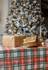 Christmas tree with craft gift boxes on plaid table