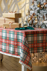 Side view plaid holiday table with gifts near tree